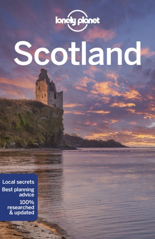 Lonely Planet Scotland by Lonely Planet. Book cover has a photograph of a derelict Scottish castle on the coast, with sea shore in the foreground.
